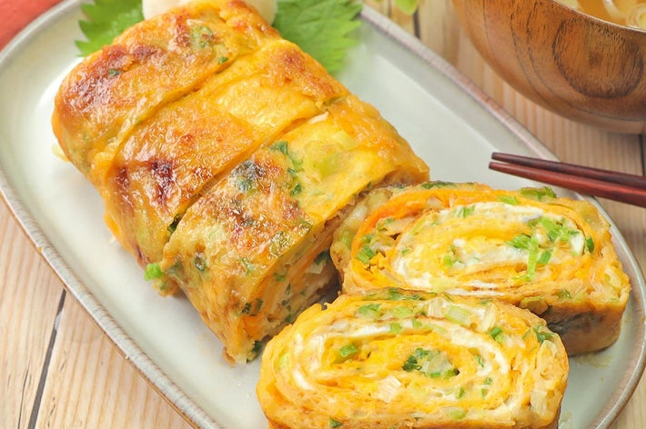 お皿に盛られた出汁巻き卵と味噌汁。刻みネギが混ぜ込まれている。食事の準備が整った様子。