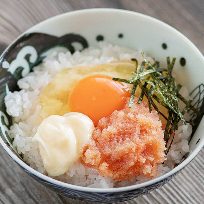 ご飯の上に生卵、明太子、海苔、マヨネーズがのった料理。シンプルで美味しそうな日本の朝食の一例。