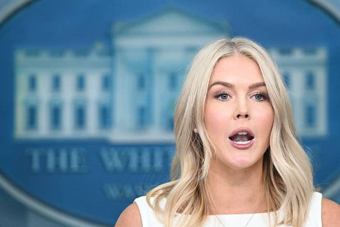 Person speaking at a podium with The White House emblem blurred in the background