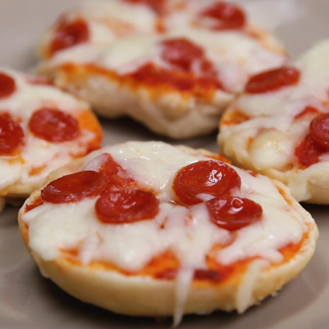 Mini bagel pizzas topped with melted cheese and pepperoni slices, arranged on a plate