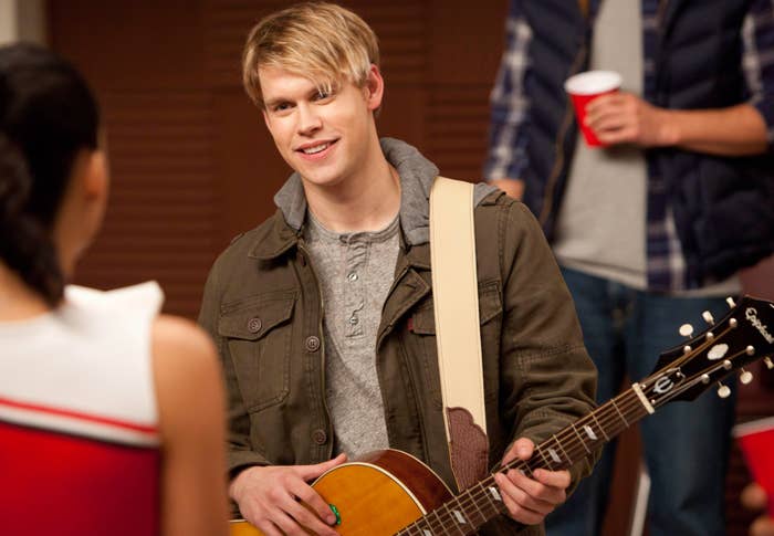 Chord Overstreet with a guitar talking to different idiosyncratic successful a cheerleader outfit astatine a casual gathering
