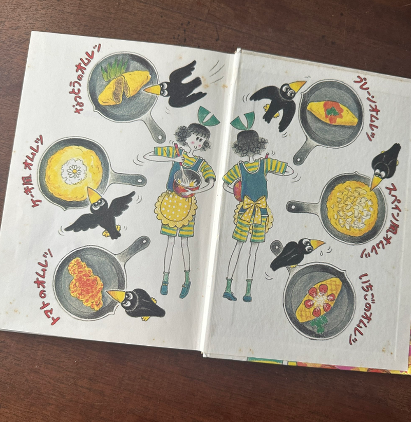 料理中のオムライスをテーマにしたイラストブックで、かわいいキャラクターとペンギンが楽しげに登場しています。