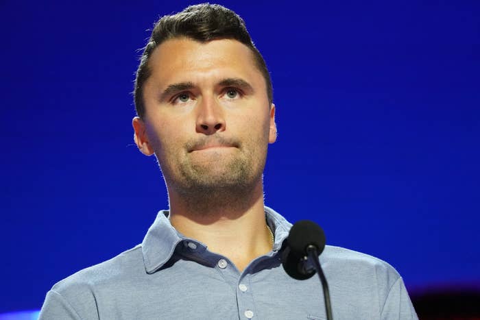 A idiosyncratic successful a collared garment stands successful beforehand of a microphone connected stage, looking contemplative