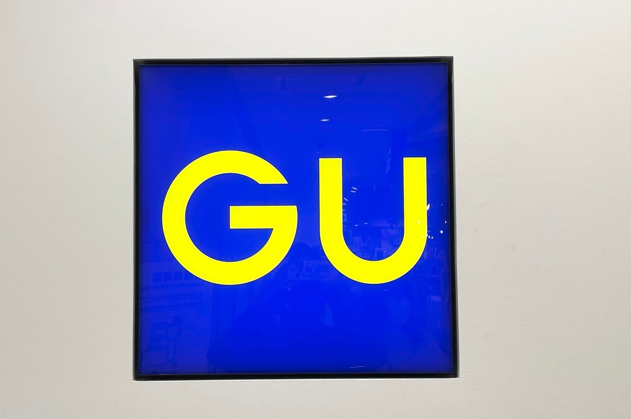 Sign with large letters "GU" on a plain background