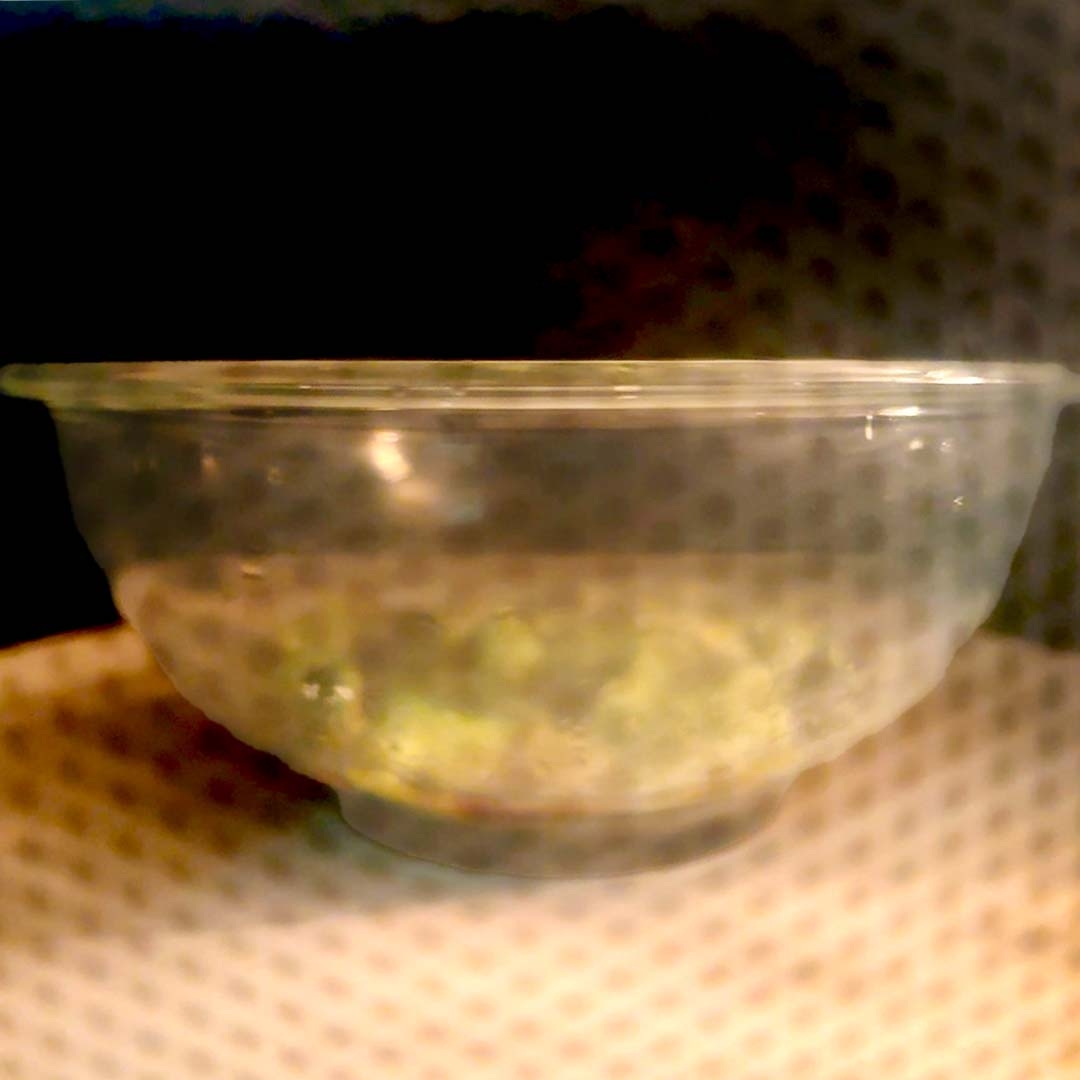 電子レンジの中で加熱されている透明なボウルに入った食べ物。