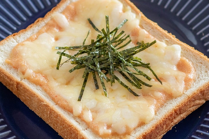 食パンの上に溶けたチーズと明太子、海苔がトッピングされています。青い皿にのせられています。
