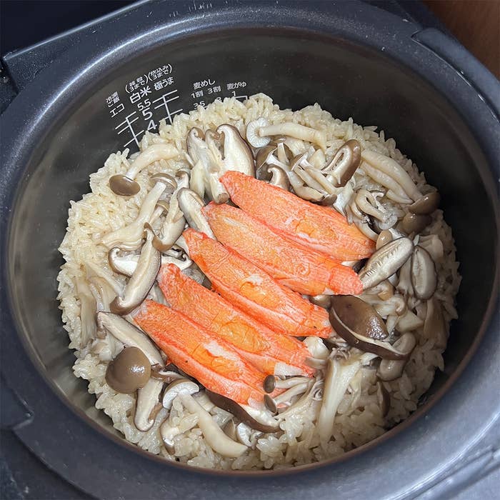 炊飯器の中で炊かれたきのことカニカマの混ぜご飯。