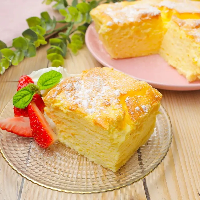 皿にのったカットされたヨーグルトスフレケーキと、飾りのイチゴとクリーム。