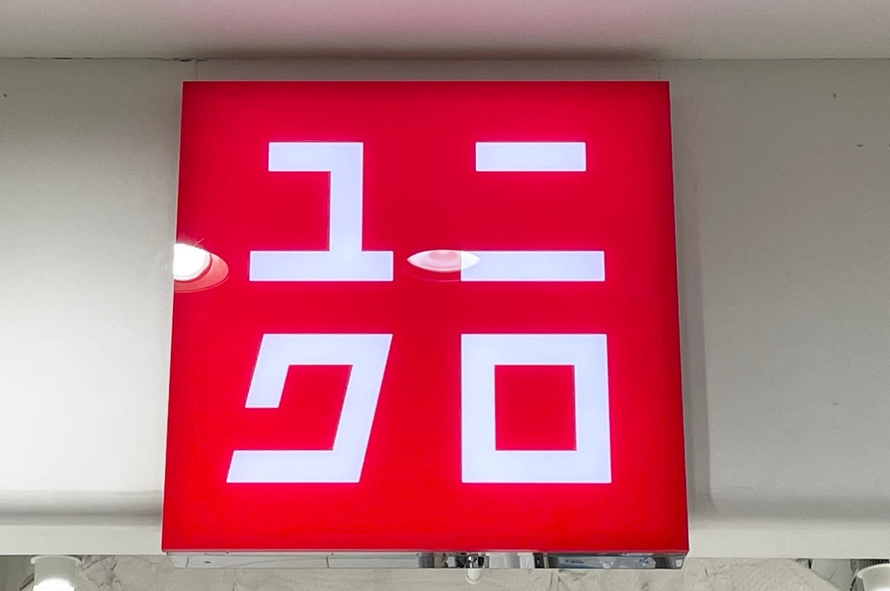 Store sign with white Japanese katakana letters on a red background, representing a popular retail clothing brand