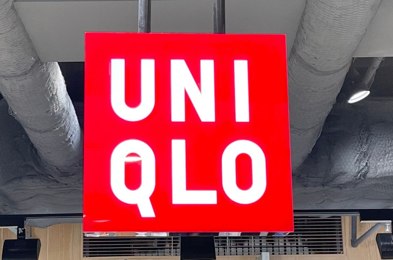 Uniqlo store interior with a red sign displaying "UNIQLO" in white letters hanging from the ceiling