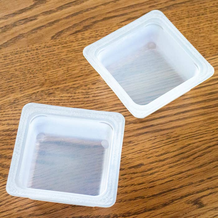 木製テーブルの上に、2つの透明なプラスチック容器。