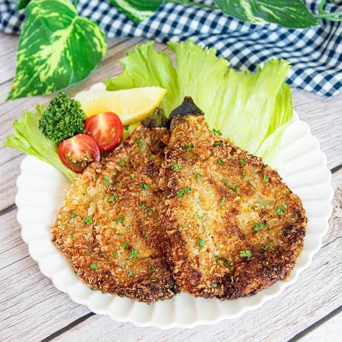 なすのバンバン揚げ。白い皿に盛られたパン粉で揚げた料理。レタス、トマト、レモンが添えられ、食欲をそそるプレゼンテーション。