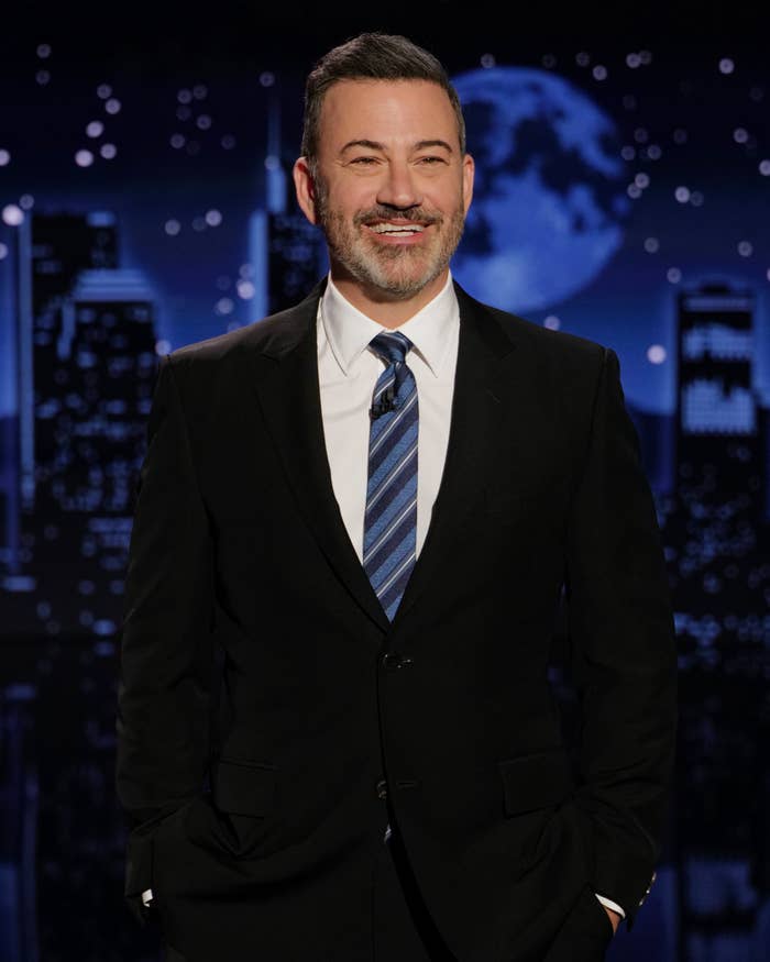 A antheral successful a suit and necktie smiles portion lasting connected a signifier with a metropolis skyline backdrop