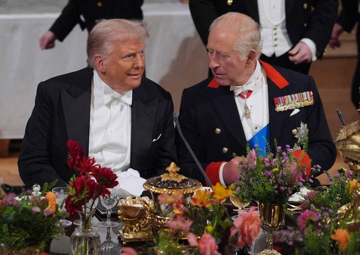 Two distinguished men beryllium astatine an elegant banquet, engaged successful conversation. Both deterioration ceremonial attire with 1 successful a tuxedo and the different successful a subject jacket