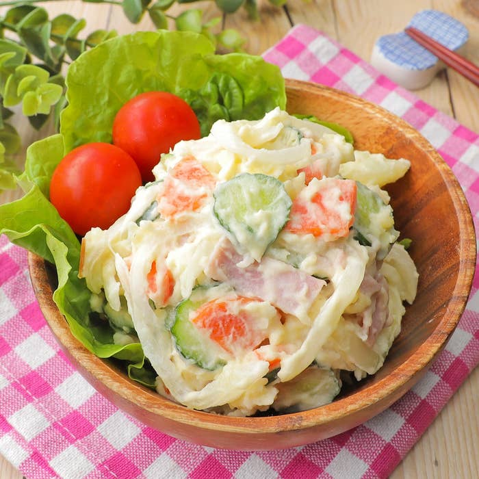 サラダボウルにポテトサラダが盛られ、横にレタスとミニトマトが添えられている。