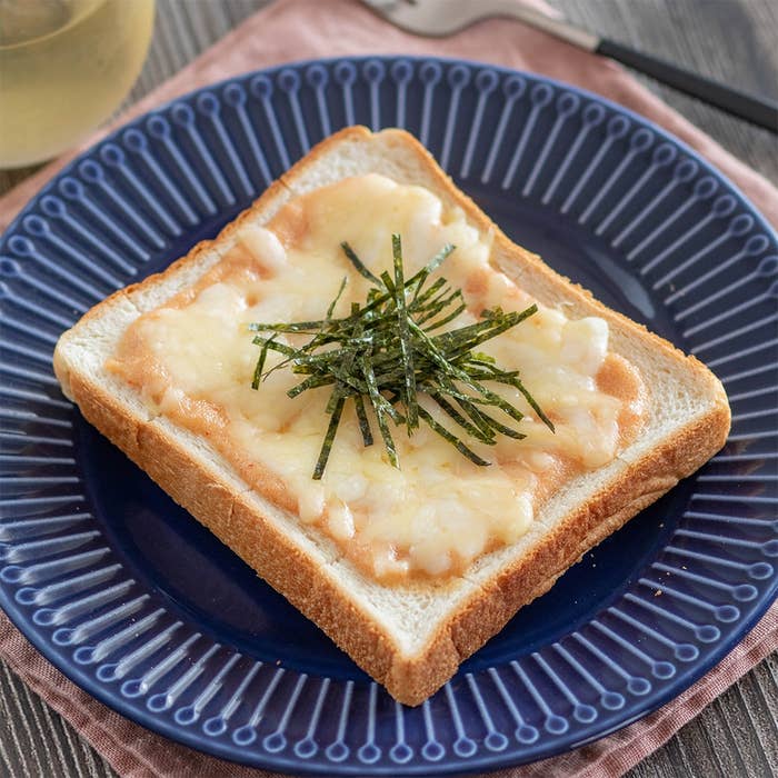 トーストの上にとけたチーズと細く切った海苔がのせられた料理。プレートに盛り付けられている。