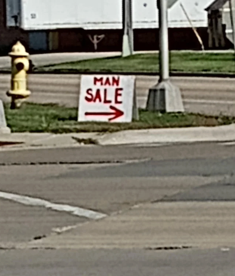 Humorous thoroughfare  motion   reads "MAN SALE" with an arrow pointing right
