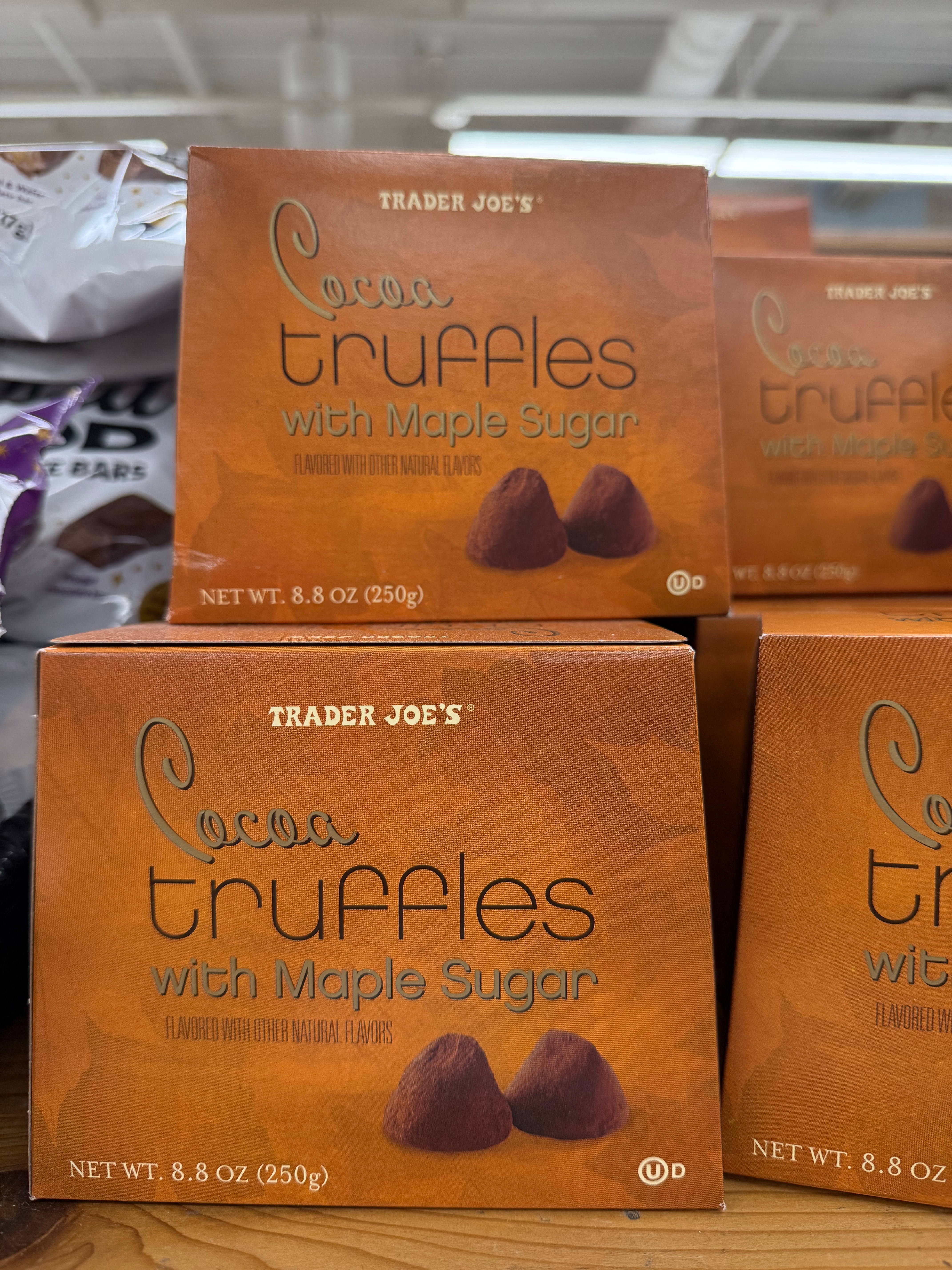 Trader Joe's cocoa truffles with maple sugar boxes stacked on a display shelf