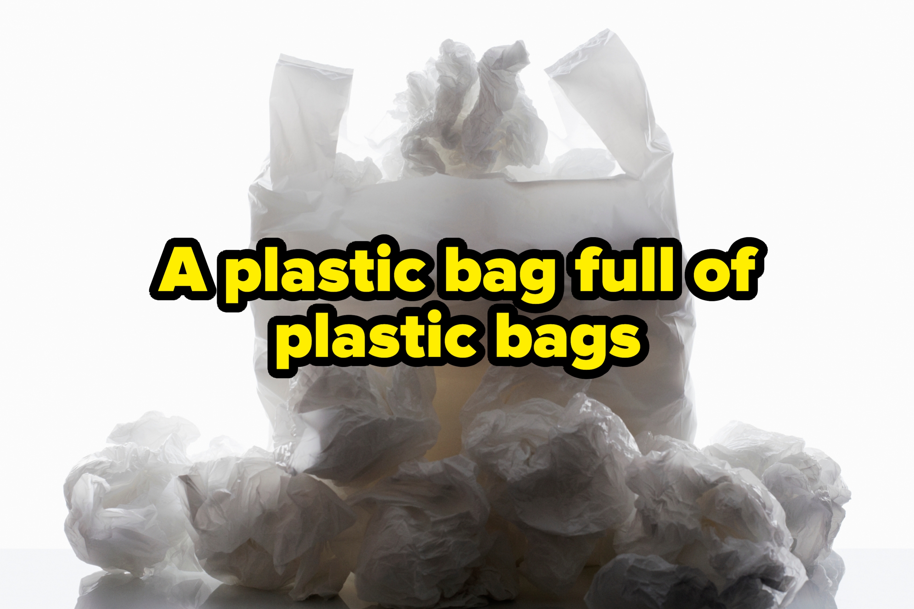 Plastic grocery bag filled with crumpled bags, placed on a reflective surface