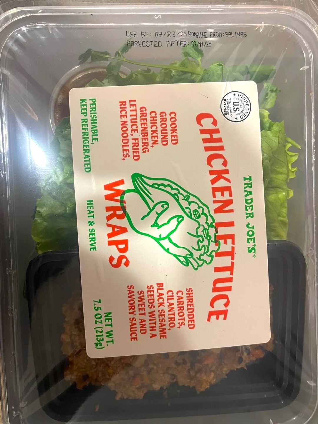 Trader Joe's Chicken Lettuce Wraps package showing ingredients like cooked chicken, rice noodles, and peanut sauce. Keep refrigerated