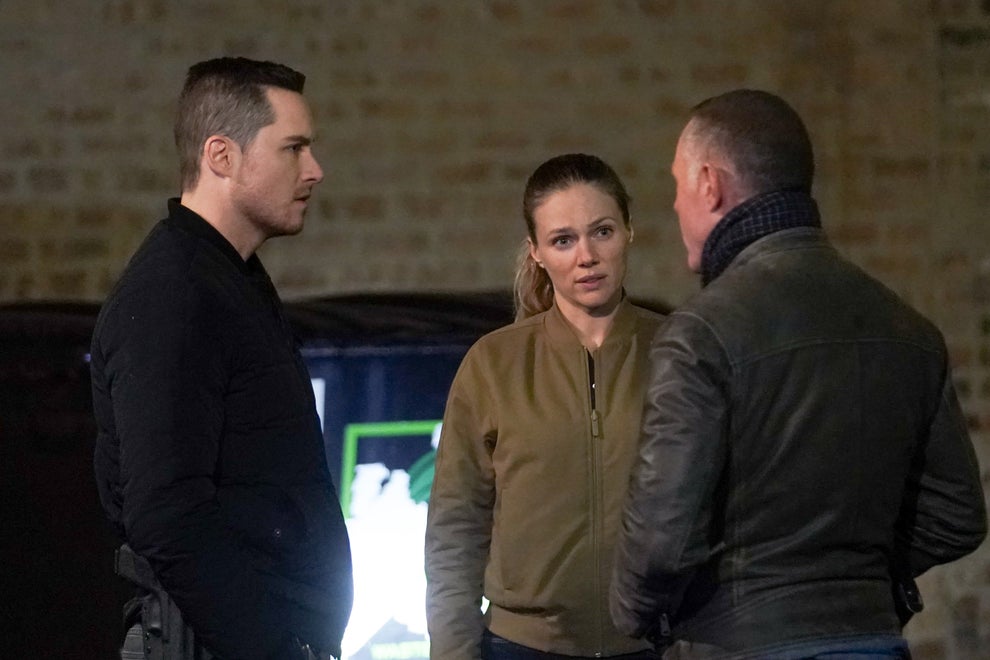 18 TV Shows That Had Some Of The Worst Endings Of All Time 10 Three people stand talking. The woman wears a casual jacket, while the two men wear darker attire. They appear focused and engaged in conversation