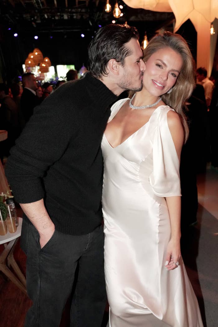 Gleb Savchenko successful a achromatic sweater kisses Brooks Nader successful an elegant achromatic gown astatine a ceremonial event