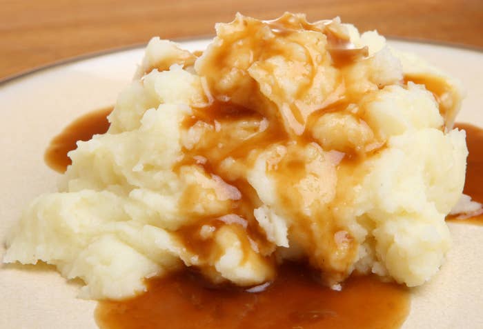 Mashed potatoes topped with gravy on a plate