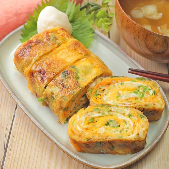 卵焼きが盛り付けられた皿がテーブルに置かれており、隣に味噌汁があります。