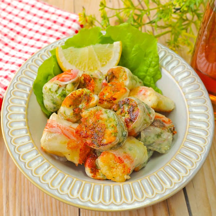 野菜と海老の揚げ春巻きが、レタスとレモンスライスを添えて皿に盛られている。
