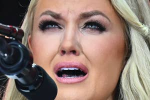 Person on stage, emotional expression, speaking into a microphone