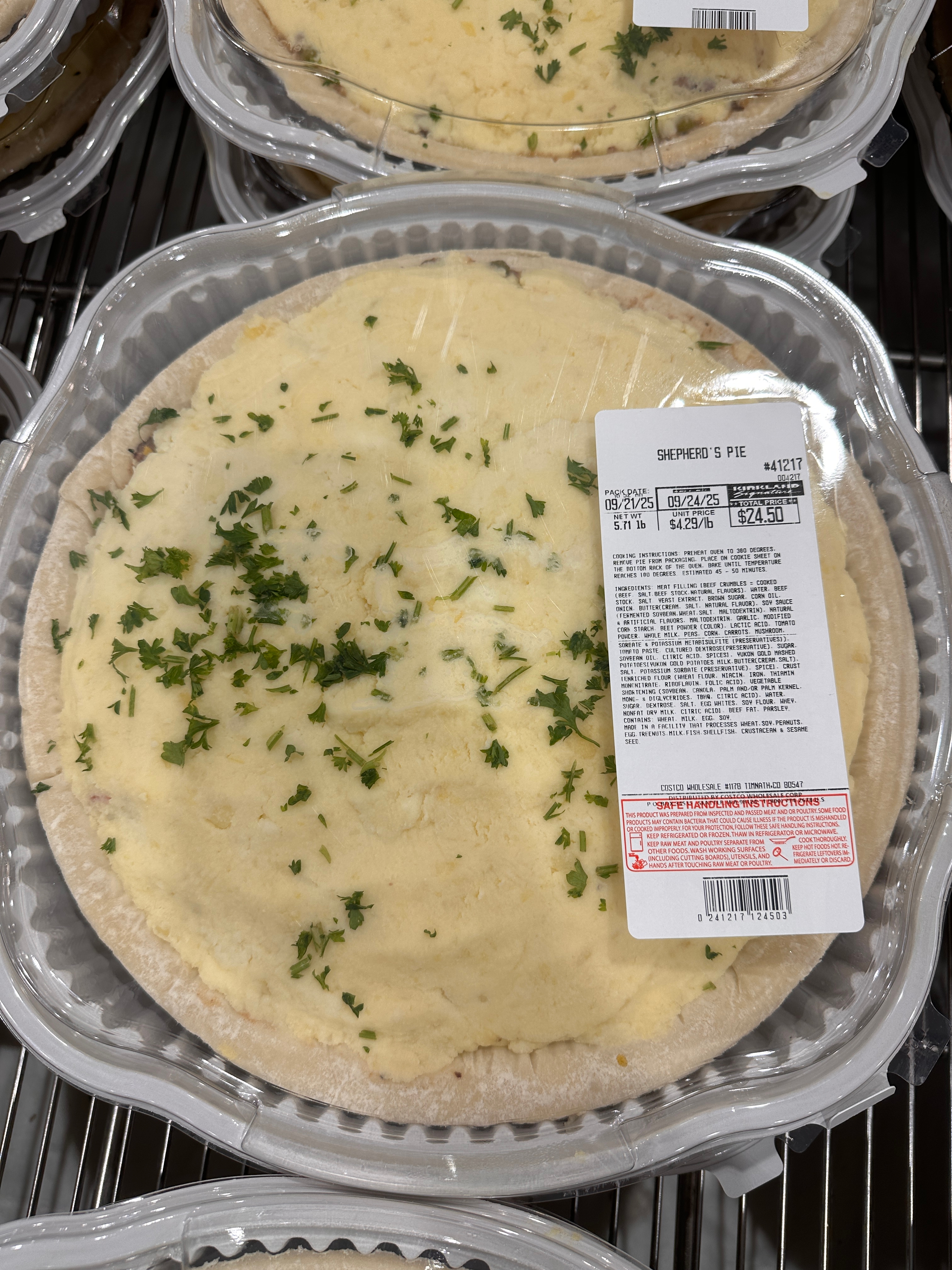 Packaged shepherd's pie with mashed potato topping, sprinkled with herbs. Label includes product details and pricing