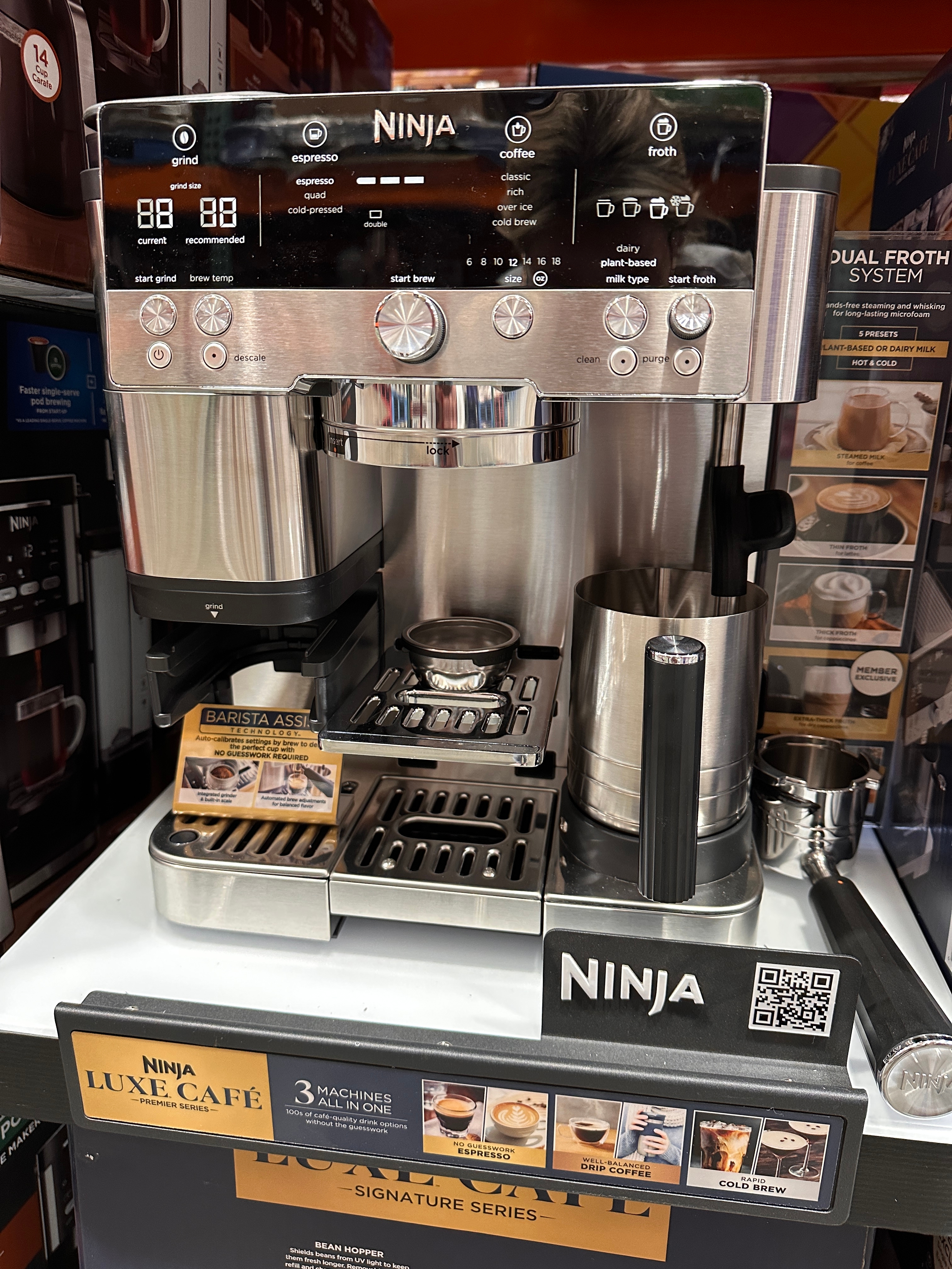 Ninja coffee machine display in a store, featuring various brewing modes and a dual frothing system with accompanying accessories