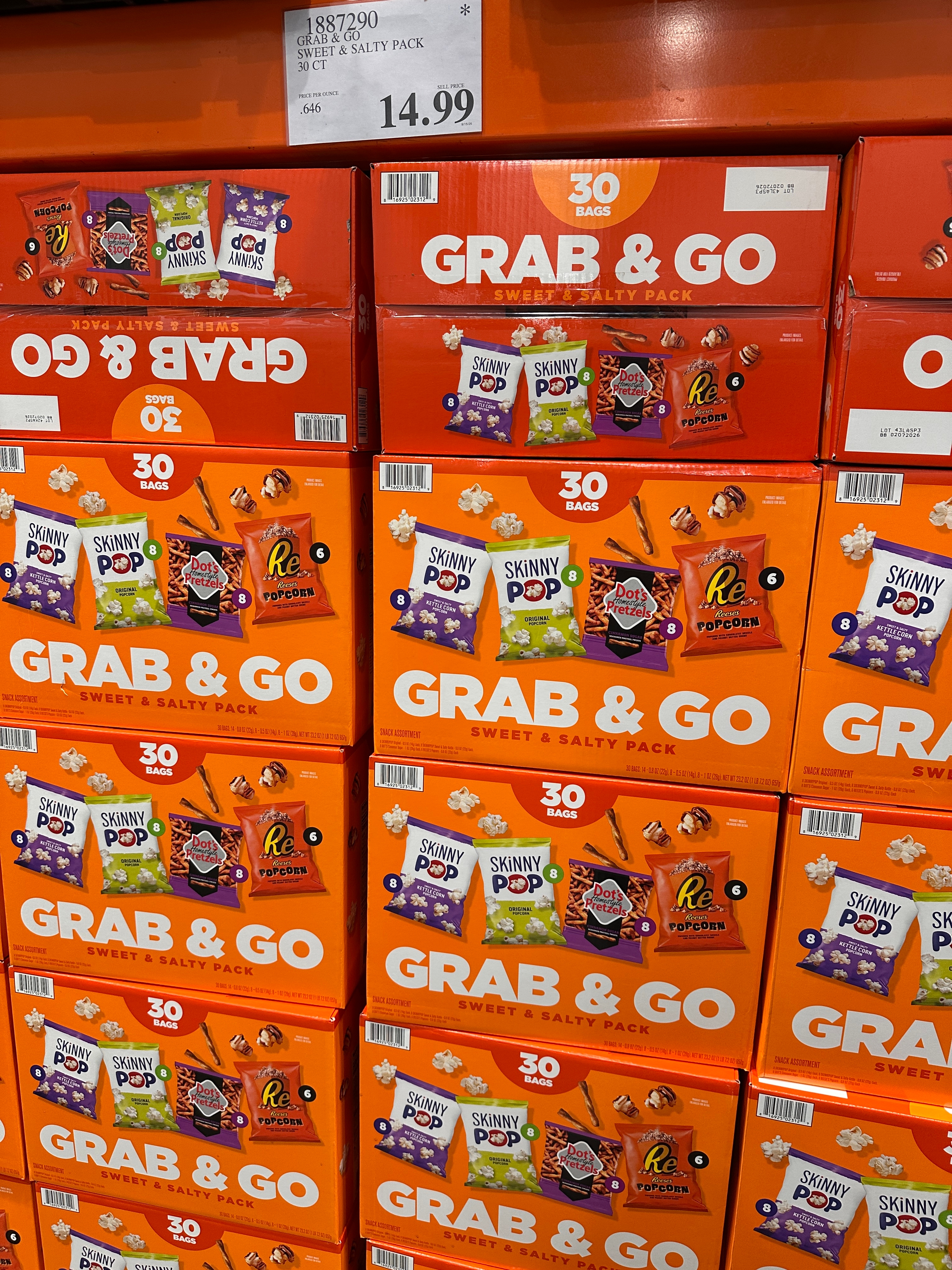 Store shelf with orange boxes labeled "Grab & Go Sweet & Salty Pack," featuring snacks like SkinnyPop and Reese's. Price: $14.99