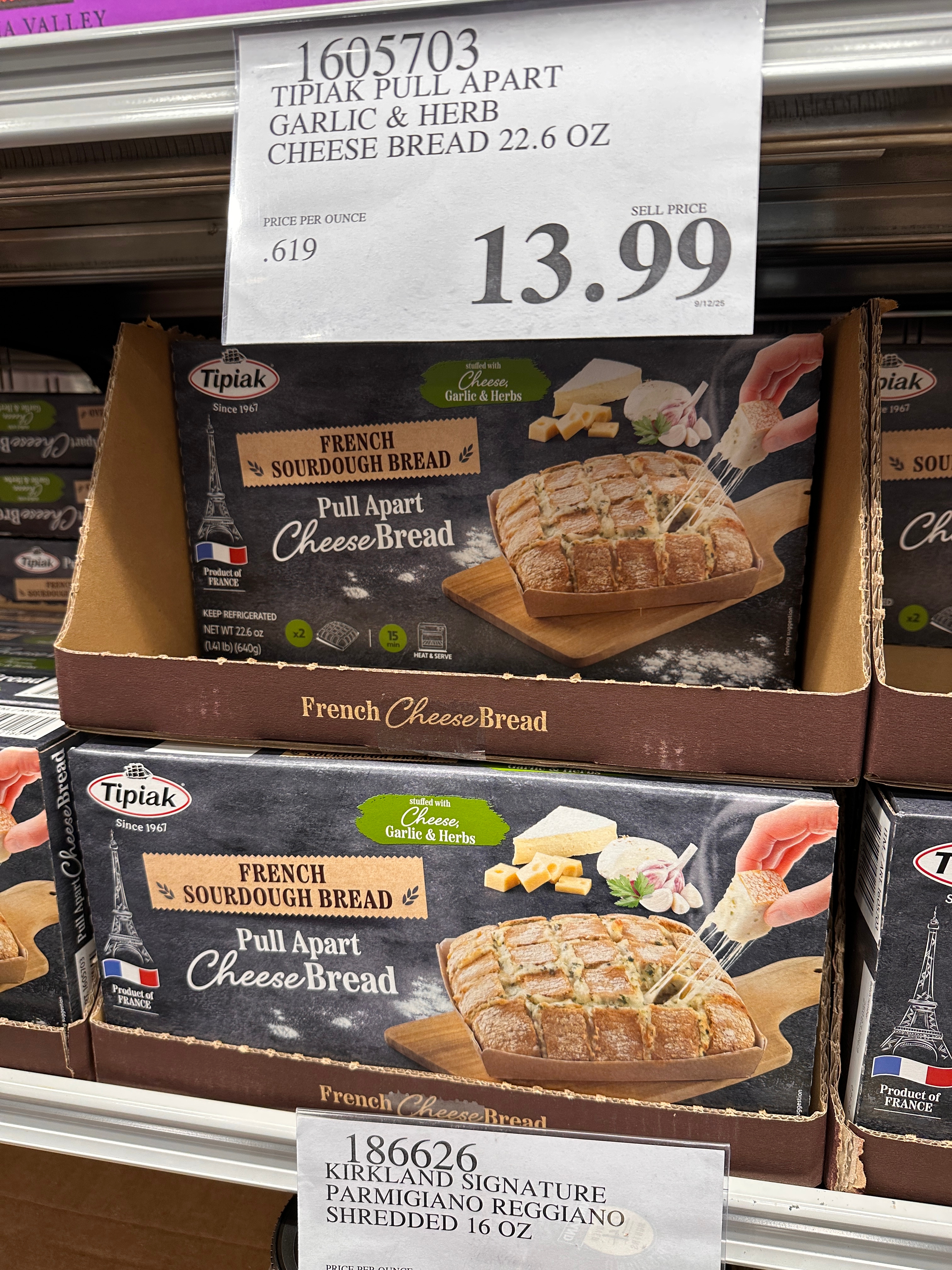 Garlic & herb cheese bread boxes on a store shelf, priced at $13.99 each