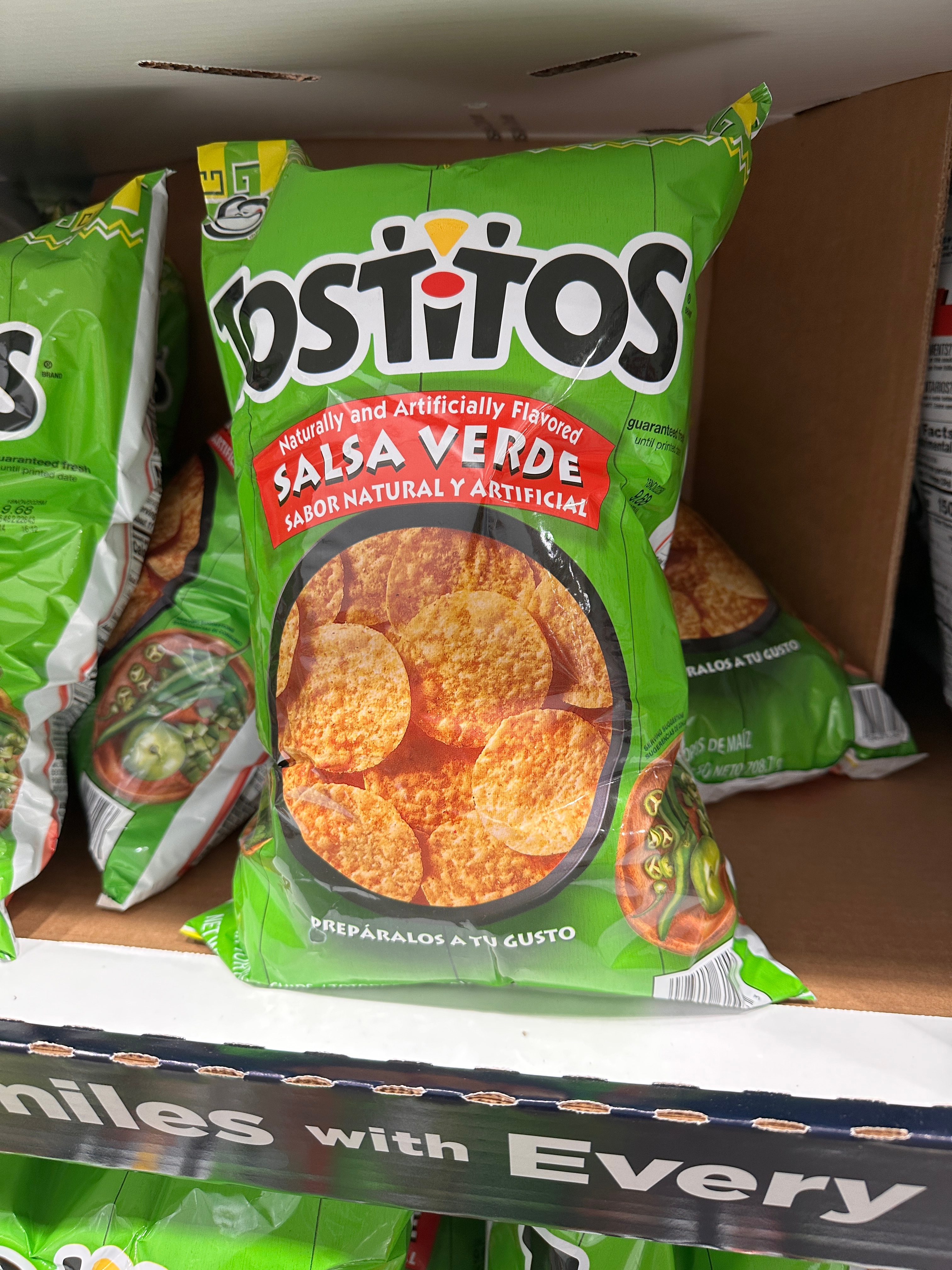 Bag of Tostitos Salsa Verde tortilla chips on a store shelf, showing chip and salsa images on the package