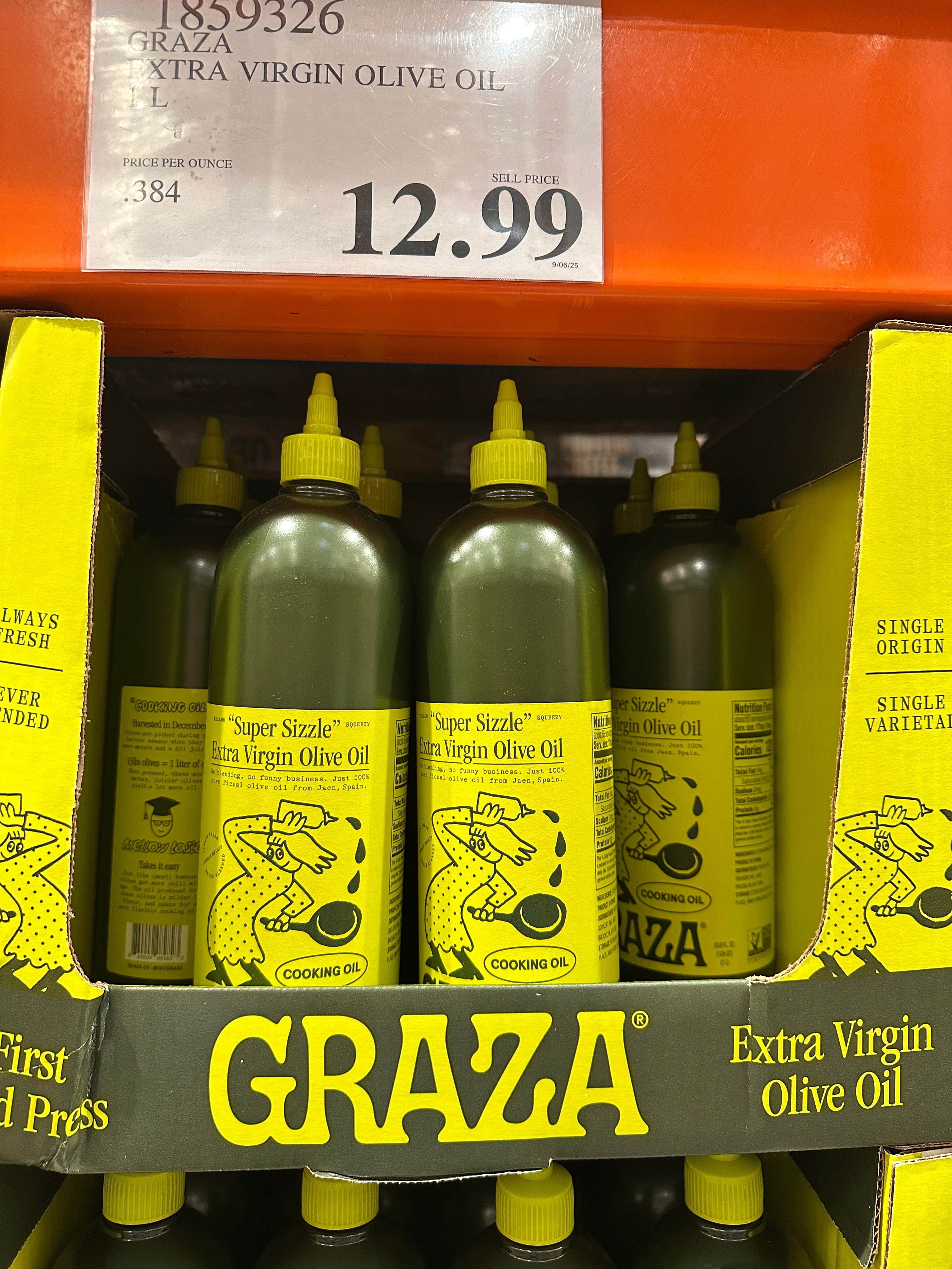 Graza extra virgin olive oil bottles with yellow labels displayed on a store shelf, priced at $12.99