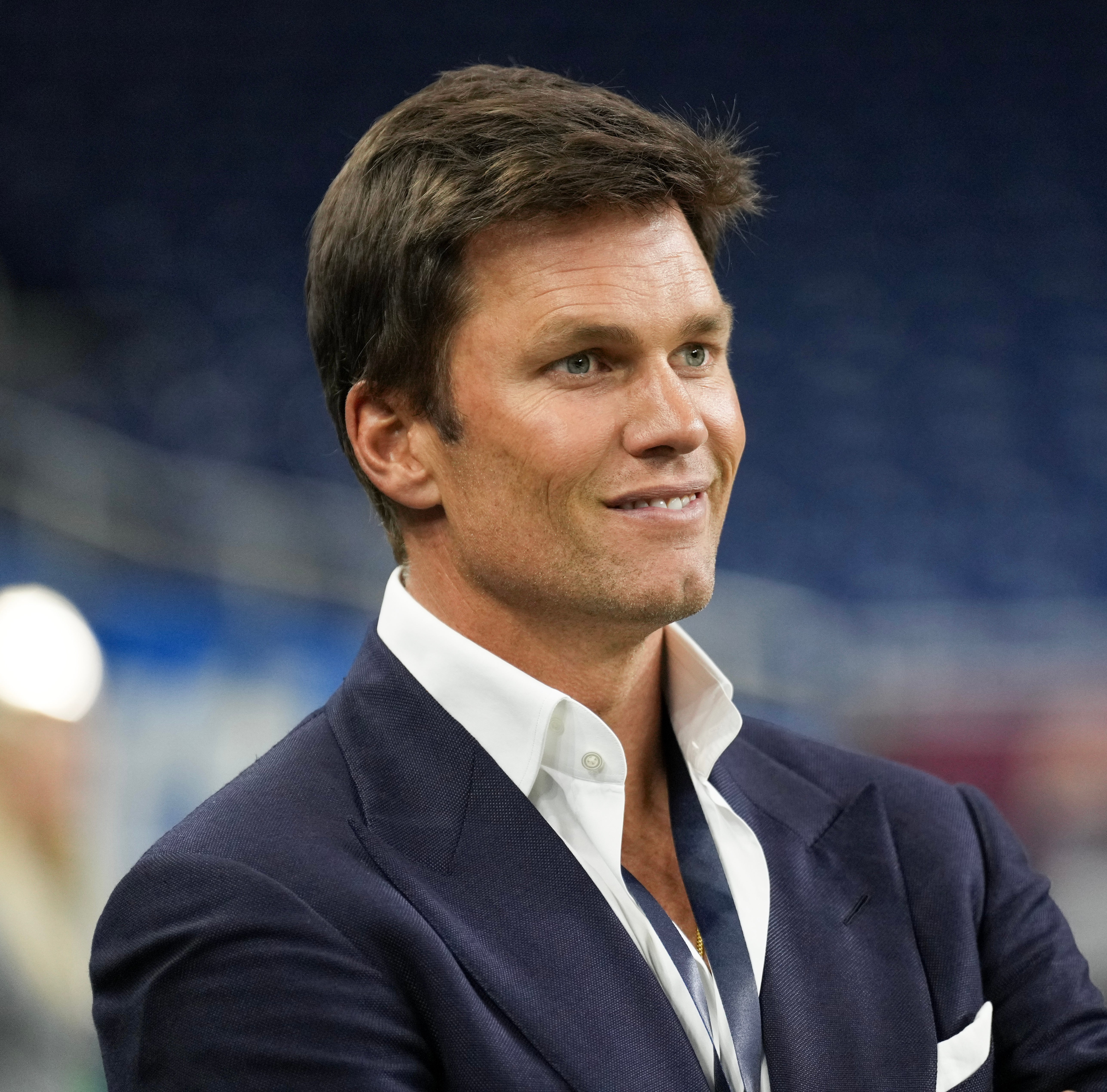 Tom Brady standing in a stadium setting