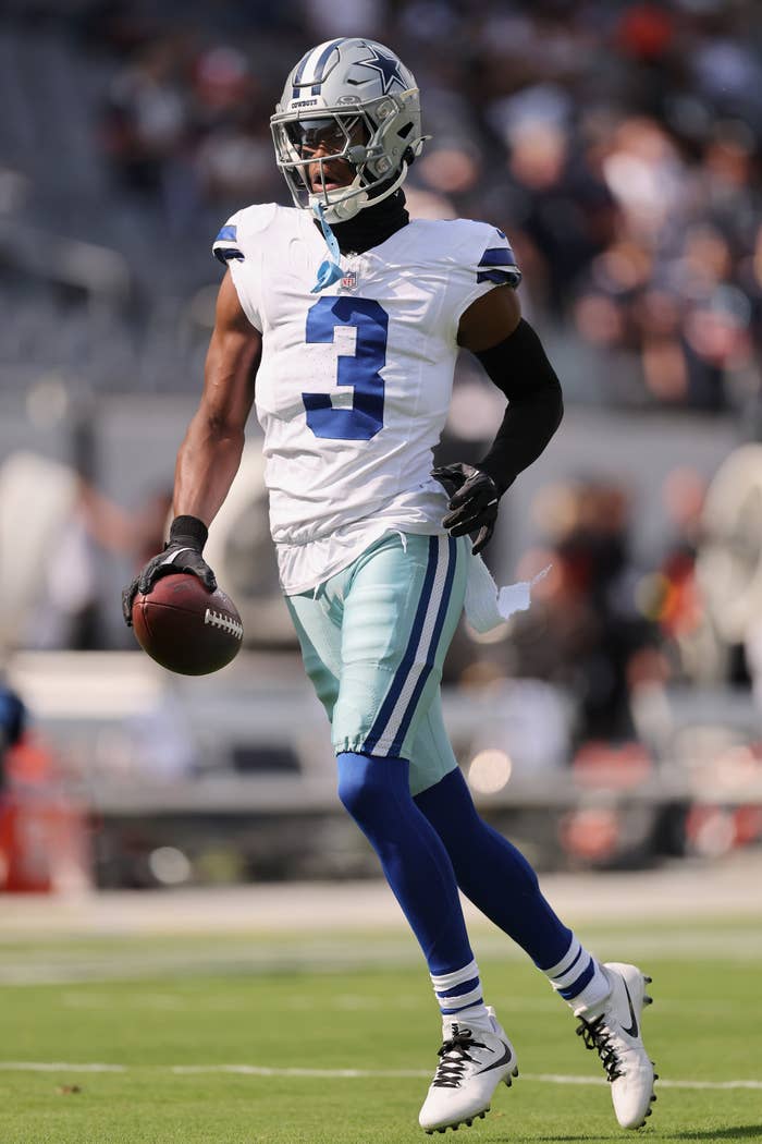 George Pickens running on a field holding a football