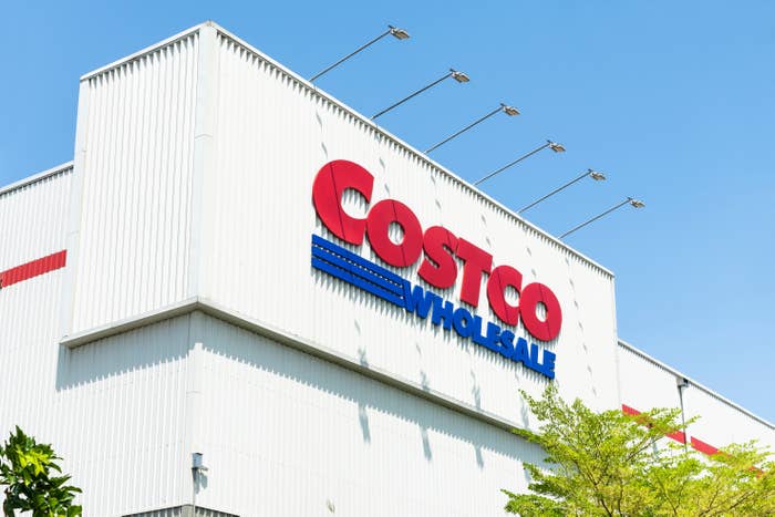 Costco Wholesale storefront with large sign, set against a clear sky