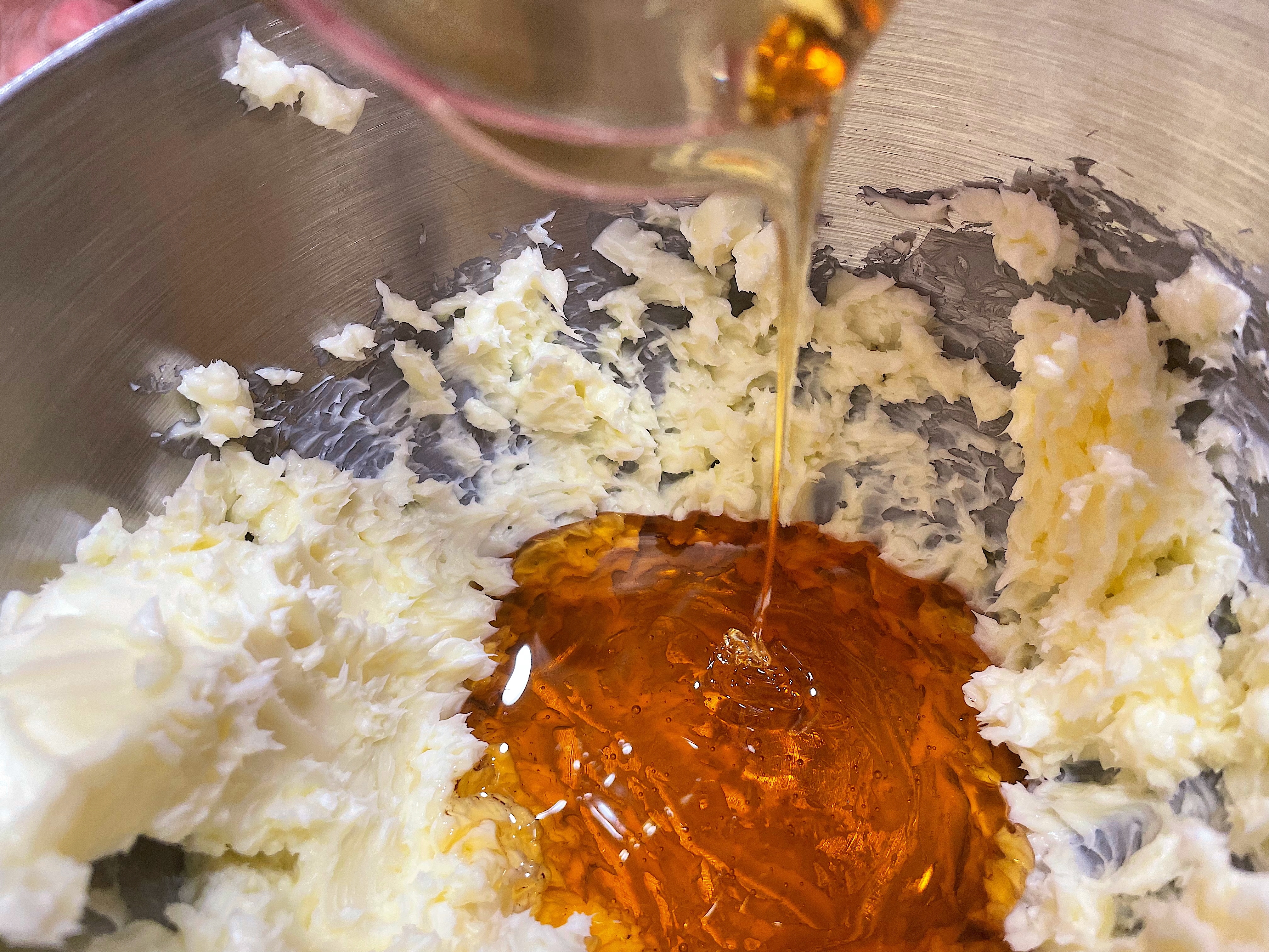 Butter and honey are being mixed in a stainless steel bowl, likely preparing for baking or cooking