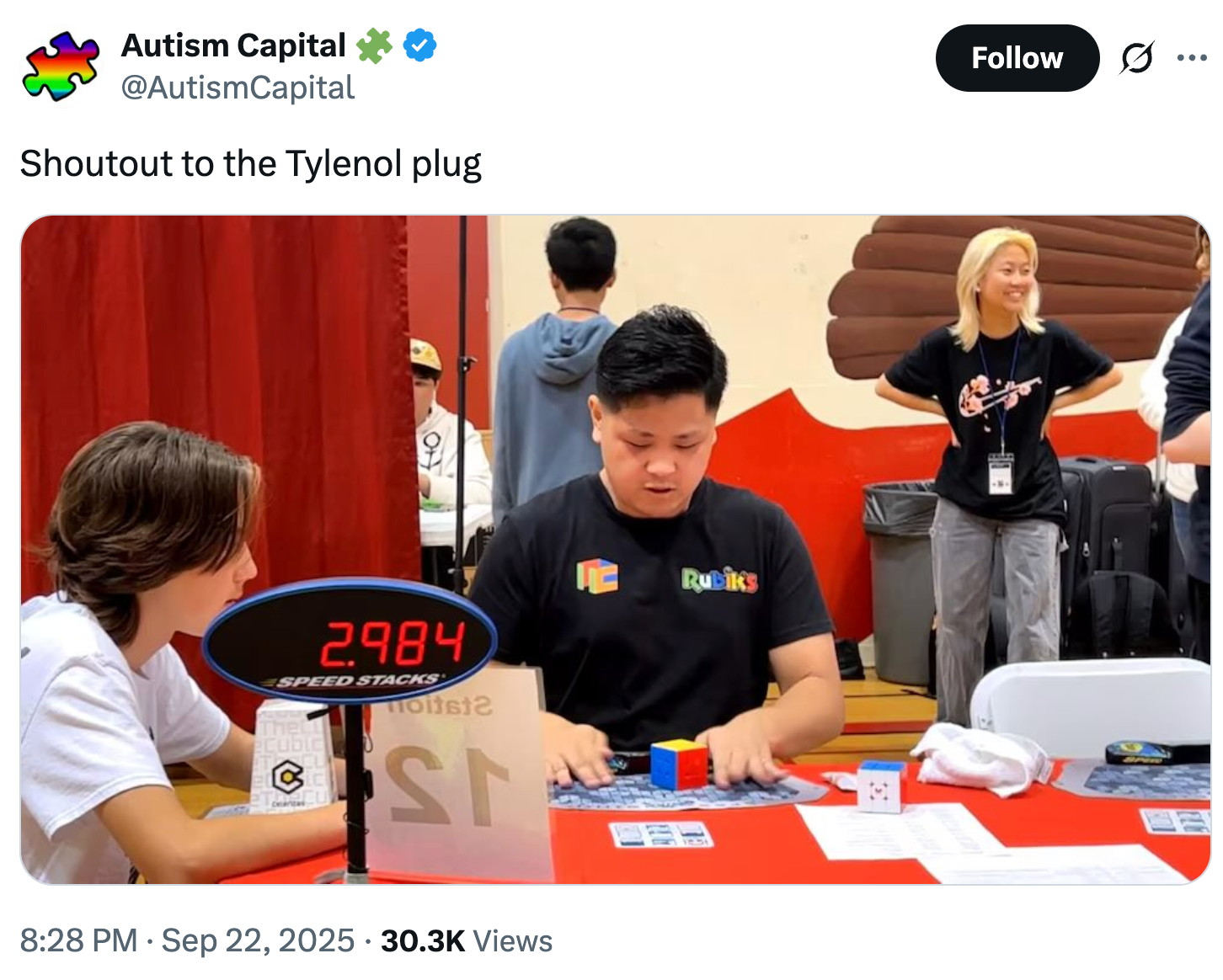 To personer driver med et hurtigstablingsspill ved et bord med en digital tidtaker, sett av andre i en tilfeldig innendørs setting