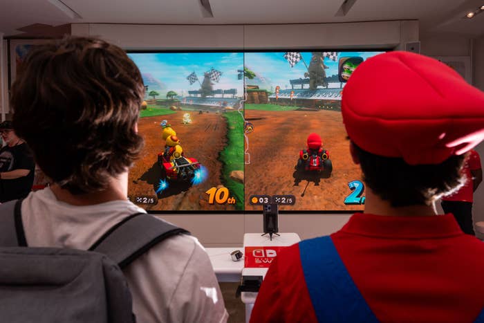 Two people play "Mario Kart" side by side