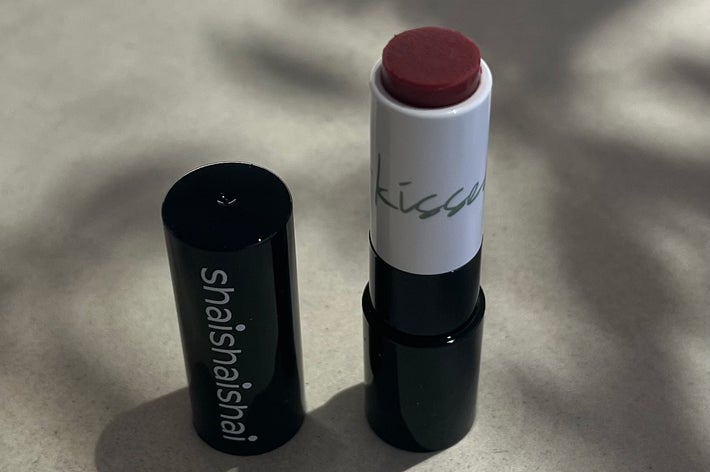 Open lipstick tube with "shaishai" written on the side, placed on a neutral surface