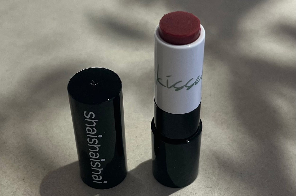 Open lipstick tube with "shaishai" written on the side, placed on a neutral surface