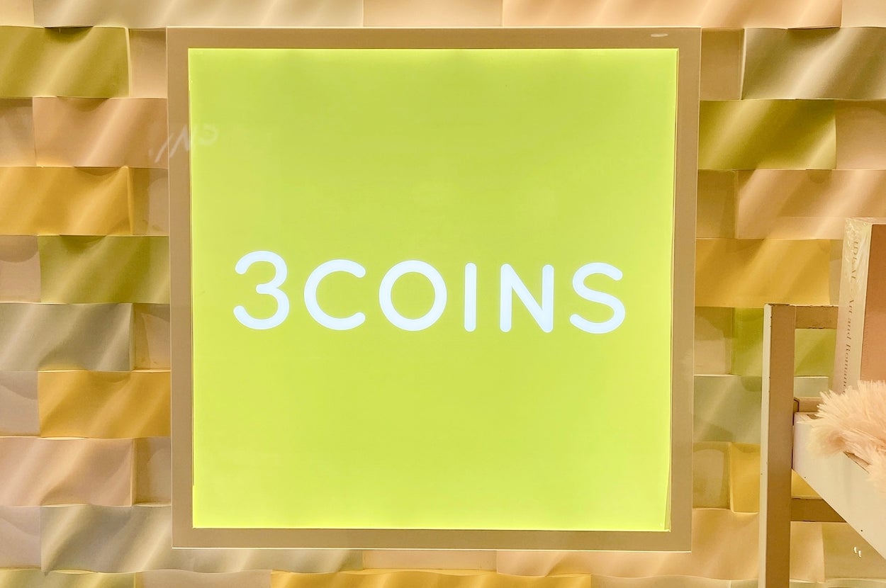壁に「3COINS」と書かれた明るい看板が設置されています。