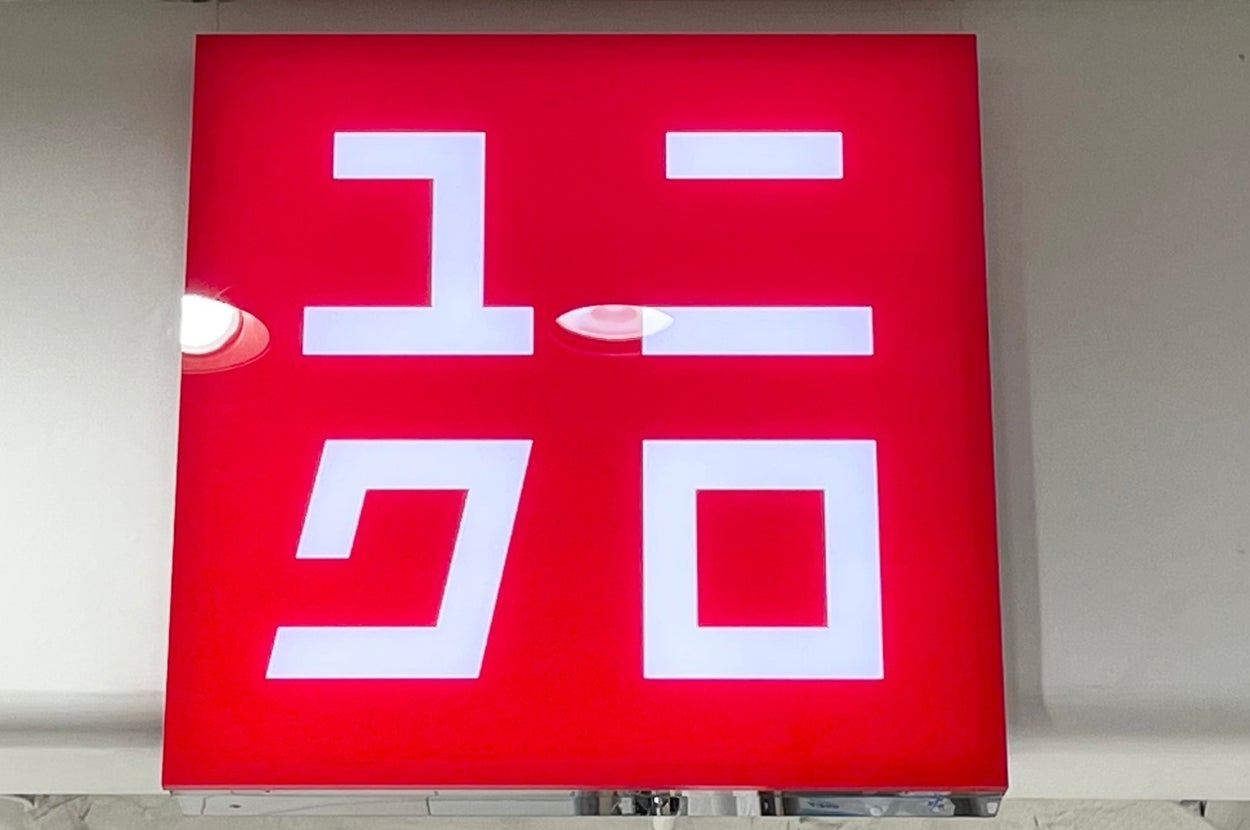 Sign with Japanese characters of the Uniqlo logo, prominently displayed in a store setting