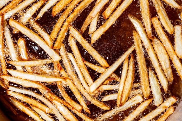 Fries cooking in hot oil, bubbling vigorously, creating a crispy texture