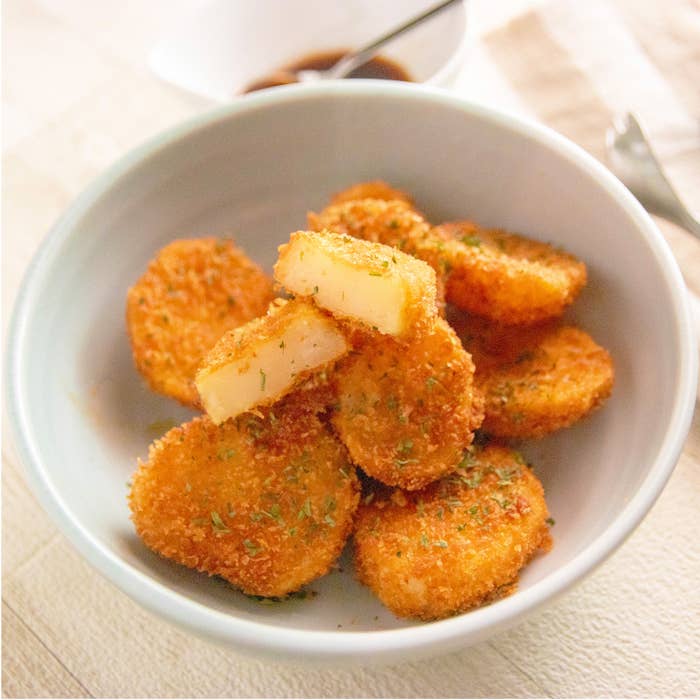 じゃがいものサクサクパン粉揚げ。パン粉がまぶされたじゃがいものフライがボウルに盛られています。ソース用の小さな器が背景に見えます。