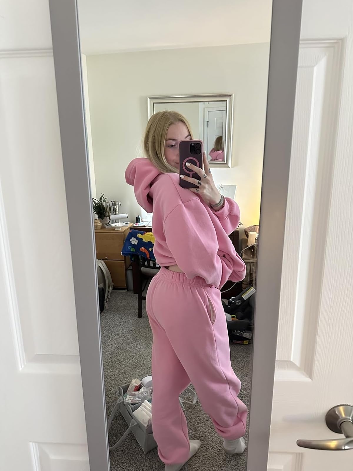 Person wearing cozy, oversized pinkish  hoodie and sweatpants, taking a reflector  selfie successful  a casual location  setting