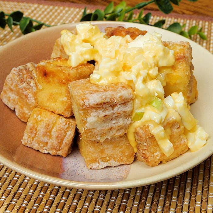 厚揚げ豆腐にクリーミーな卵サラダがかかった料理。皿の上に盛り付けられ、食欲をそそる見た目。